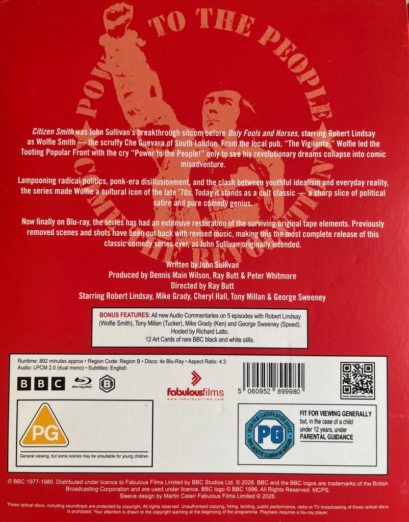 Back cover of the Blu-ray box set for Citizen Smith, which has a red background with a faded image of Wolfie pumping his fist in the air triumphantly. Paragraphs of white text over the top describe the show and credit the key members of the cast and crew. A white box then lists the bonus material, before a larger white box provides technical, copyright and other information.