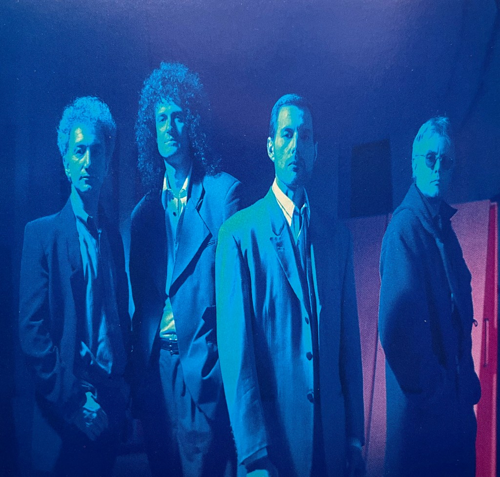 A blue-tinted photo of the 4 members of Queen posing together, from the booklet with their Innuendo album.