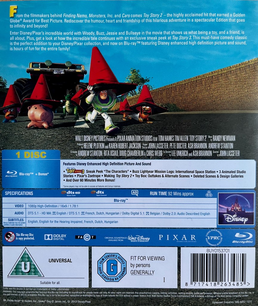 Blu-ray back cover for Toy Story 2, showing some of the toys running along a road holding red traffic cones over their heads. A description of the movie is shown above them and extra features are listed below.
