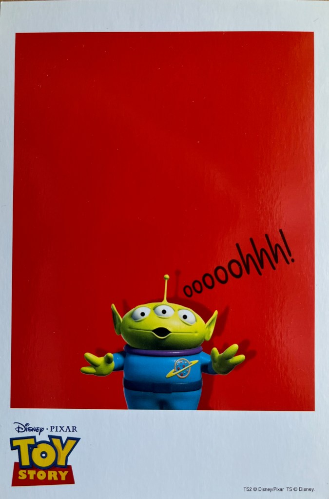 A Toy Story art card showing a small green alien with 3 eyes standing against a red background, exclaiming Ooooohhh, which is shown in black ink next to it.